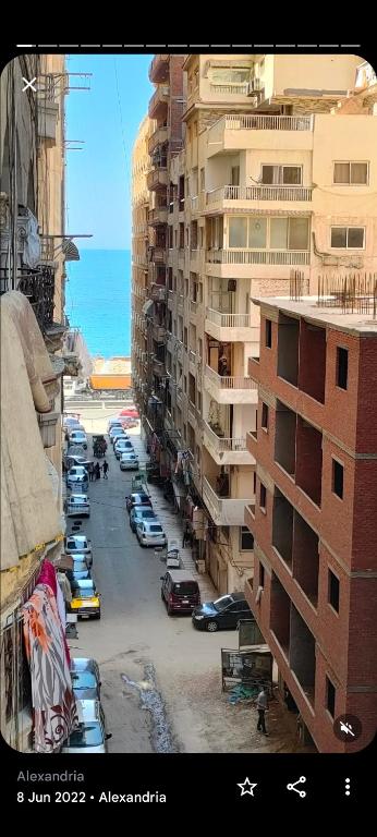 una calle de la ciudad con coches estacionados junto a edificios altos en شقه فيو بحر ميامي مكيفه, en Alejandría