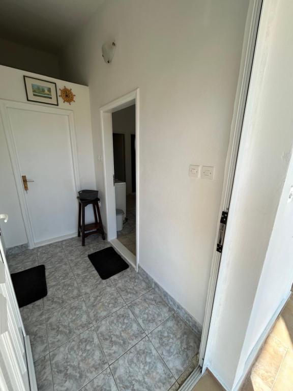 an empty room with a door and a tile floor at Apartmani Paklenica in Razvala