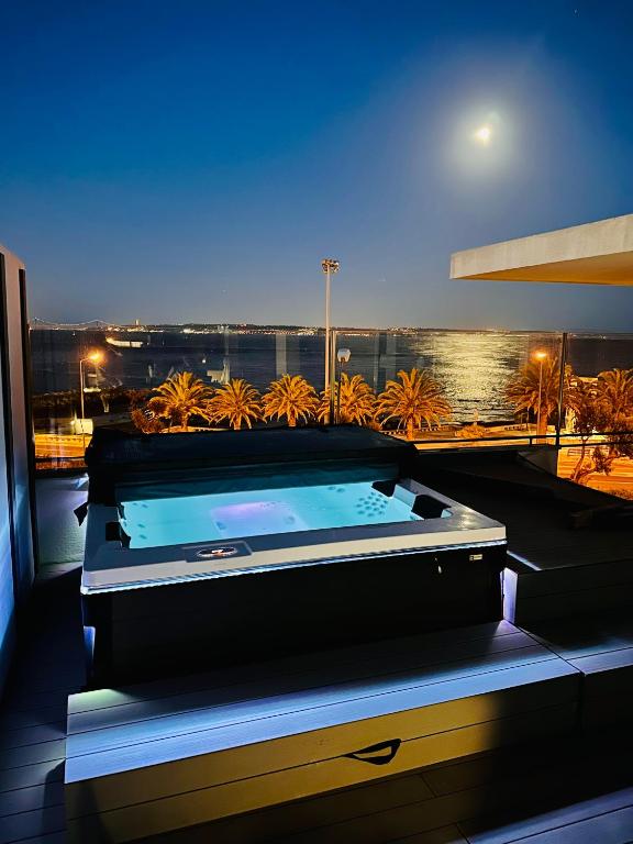 a hot tub on a balcony with a view of the ocean at Casa do Mar Oeiras in Oeiras