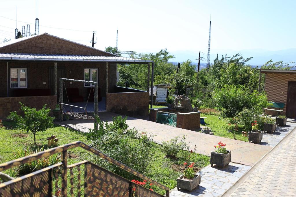 a garden with potted plants and a house at Sun-Kissed House in Kutaisi