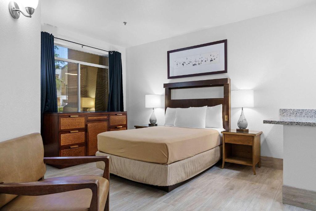 a hotel room with a bed and a chair at Metro Extended Stays , Chandler - Cozy 2 Beds in Chandler