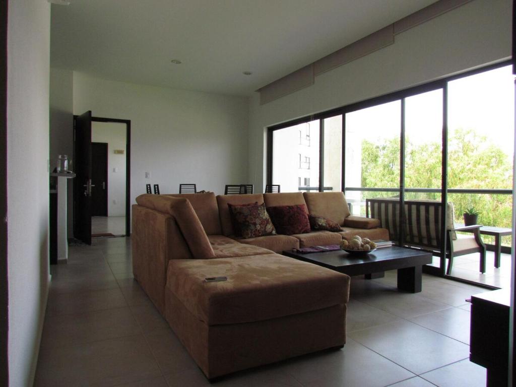 ein Wohnzimmer mit Sofa und Tisch in der Unterkunft Departamento Paraiso Country Club-Morelos in Emiliano Zapata