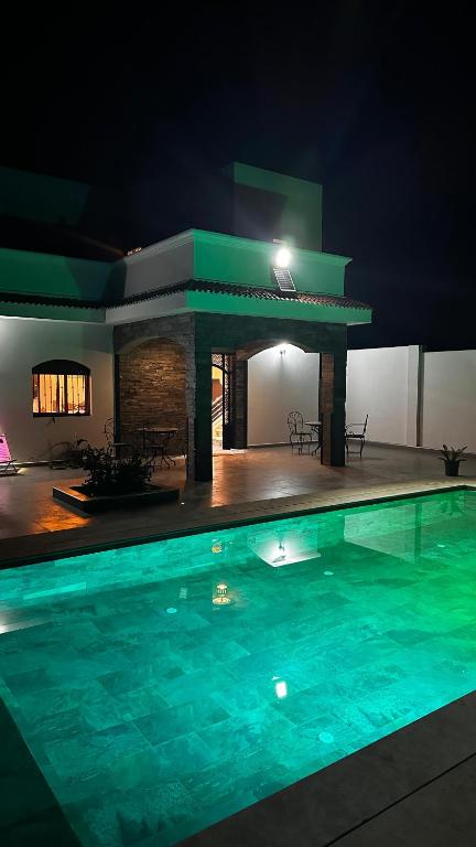 a large swimming pool at night with a house at Villa Ghailan in Asilah