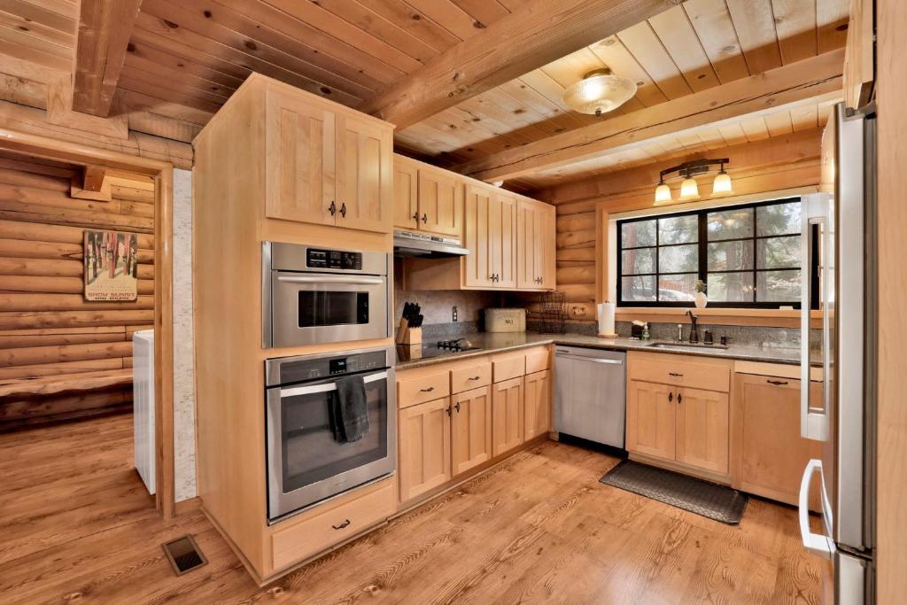 een keuken met houten kasten en roestvrijstalen apparatuur bij Woodland log #1887 in Big Bear Lake
