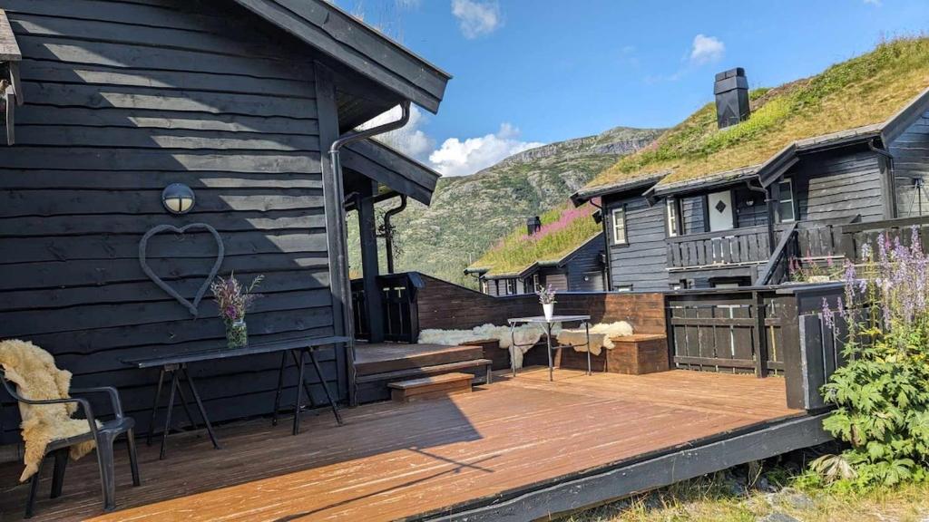 a deck of a house with a table and chairs at Romslig leilighet sommer og vinter in Tyinkrysset