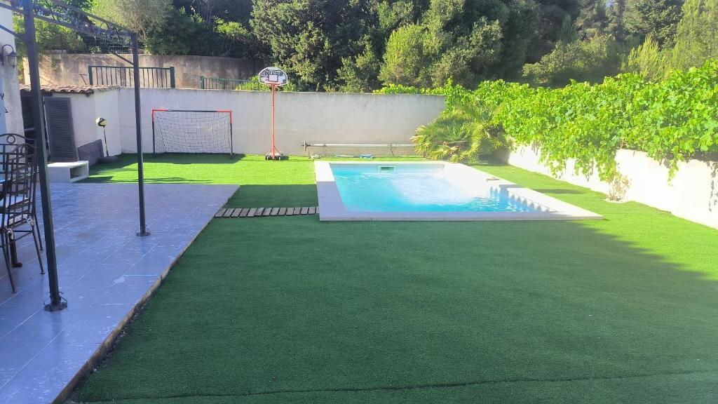 a backyard with a swimming pool and green grass at La Sudiste in Six-Fours-les-Plages