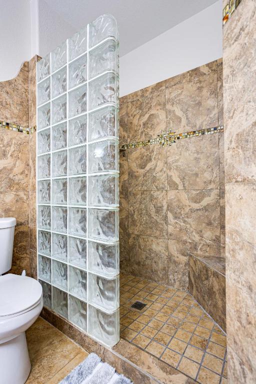 a bathroom with a toilet and a shower with glass panels at Southern #2068 Mesa in Mesa