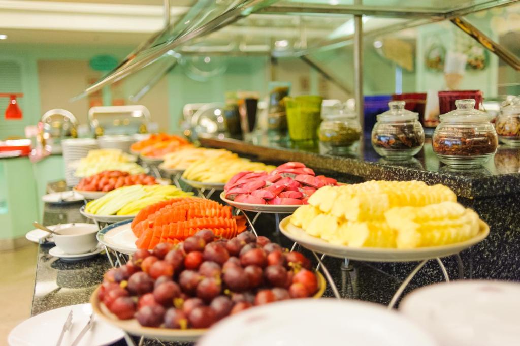 A refrigerated buffet display featuring sliced and whole fresh fruit.