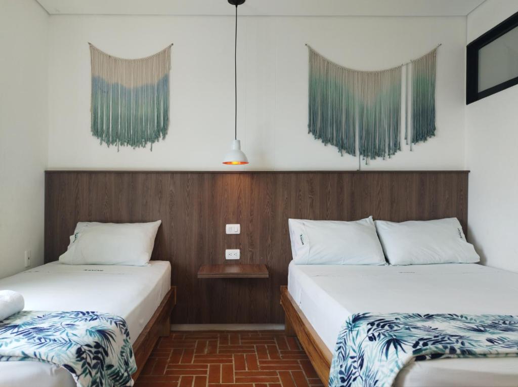 Postel nebo postele na pokoji v ubytování Hotel Macaw Cúcuta