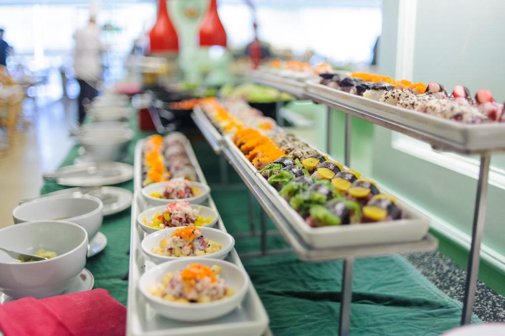 A long buffet display of small prepared dishes and colorful toppings.