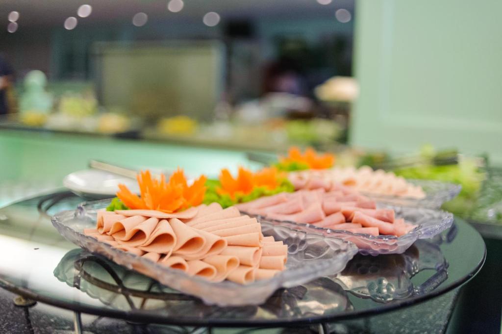 A chilled buffet platter of sliced cold meats on a glass table.