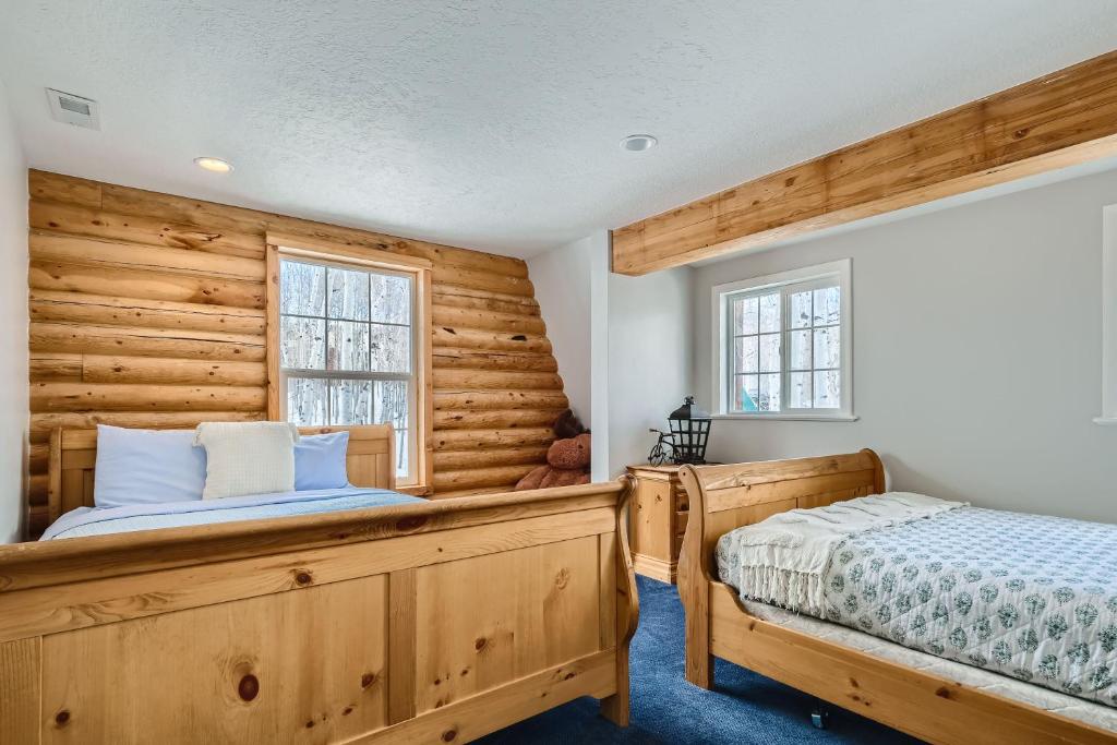 Un dormitorio con dos camas y una pared de madera. en 6 Bedroom Cabin by Xquisite Rentals, en Heber City