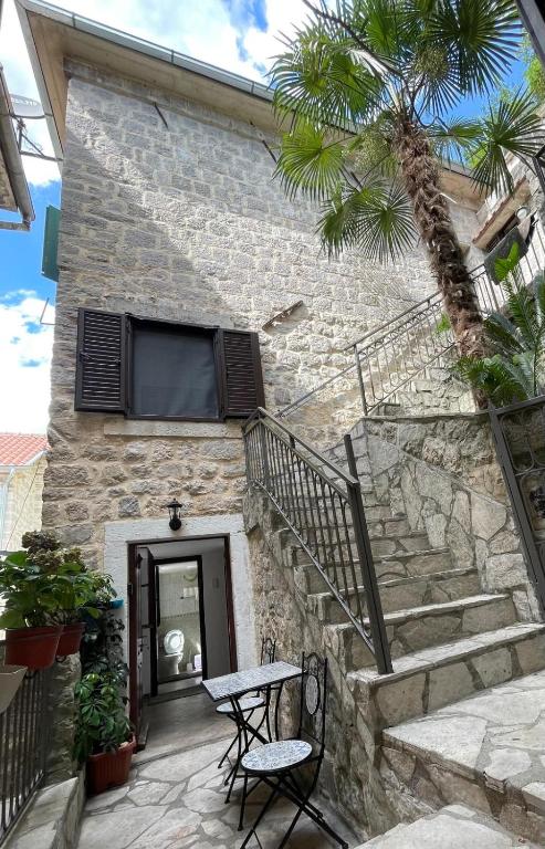 a stone building with stairs and a table and chairs at Kotor Old Town Cozy Escape in Kotor