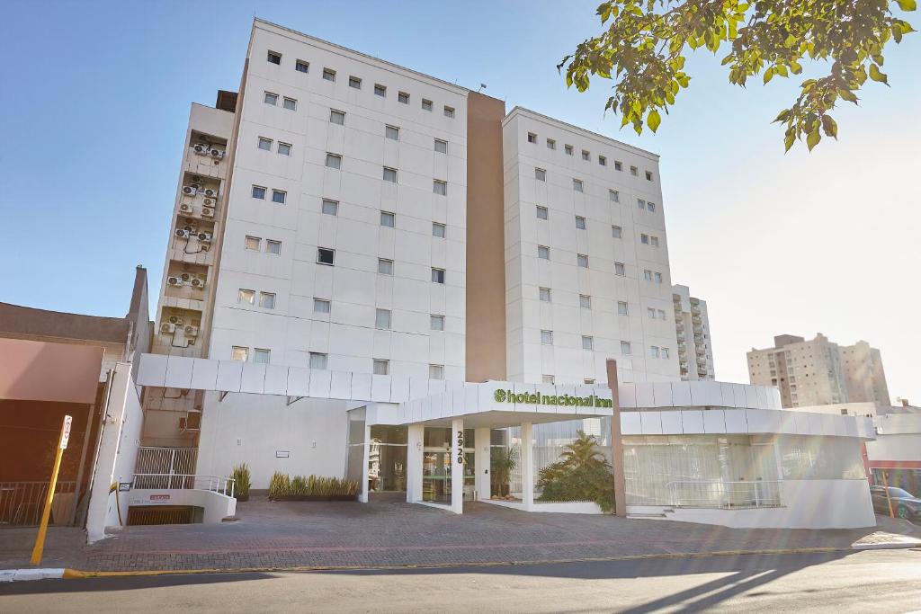 Un gran edificio blanco con un cartel en él. en Hotel Nacional Inn Bauru, en Bauru