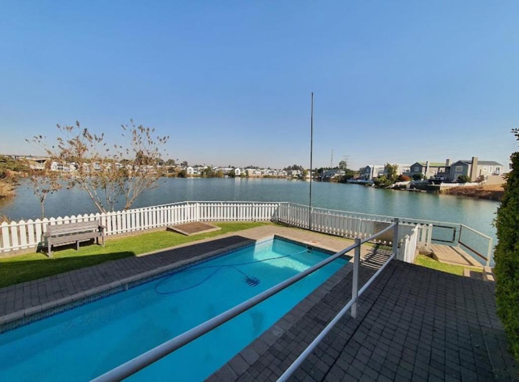 a swimming pool next to a body of water at BKM Lake View Retreat at Leisure Bay Estate in Pretoria