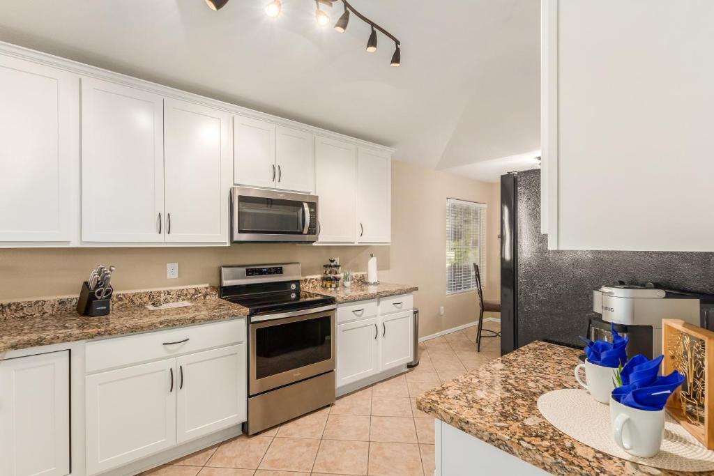 a large kitchen with white cabinets and appliances at 136th Surprise in Surprise