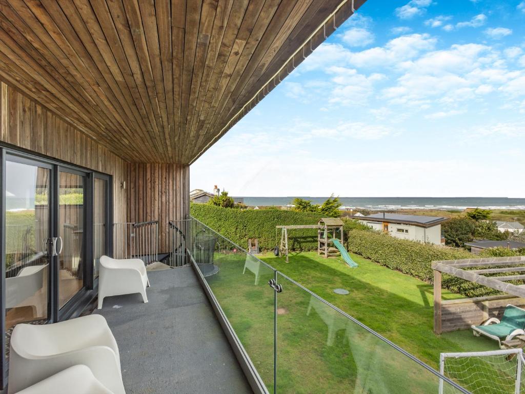 a balcony with a view of the ocean at Tregarden in Poundstock