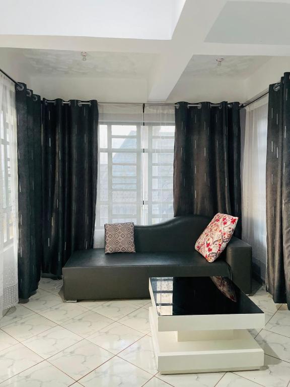a living room with a couch and a window at Jordan House in Voi