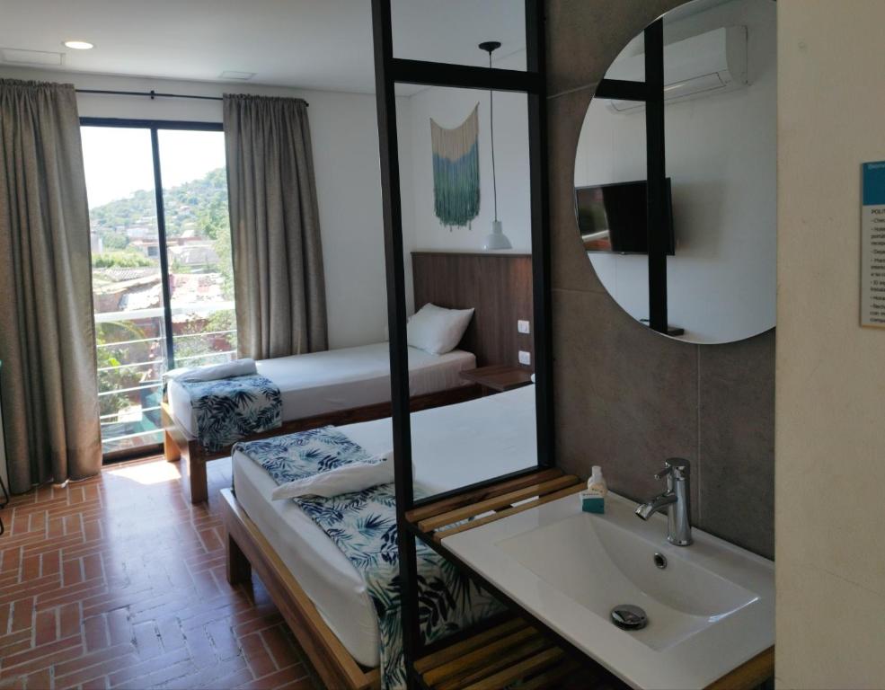 Postel nebo postele na pokoji v ubytování Hotel Macaw Cúcuta