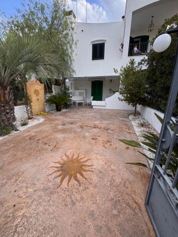 a courtyard of a house with a building at Casa delle Mimose Baia Verde in Baia Verde