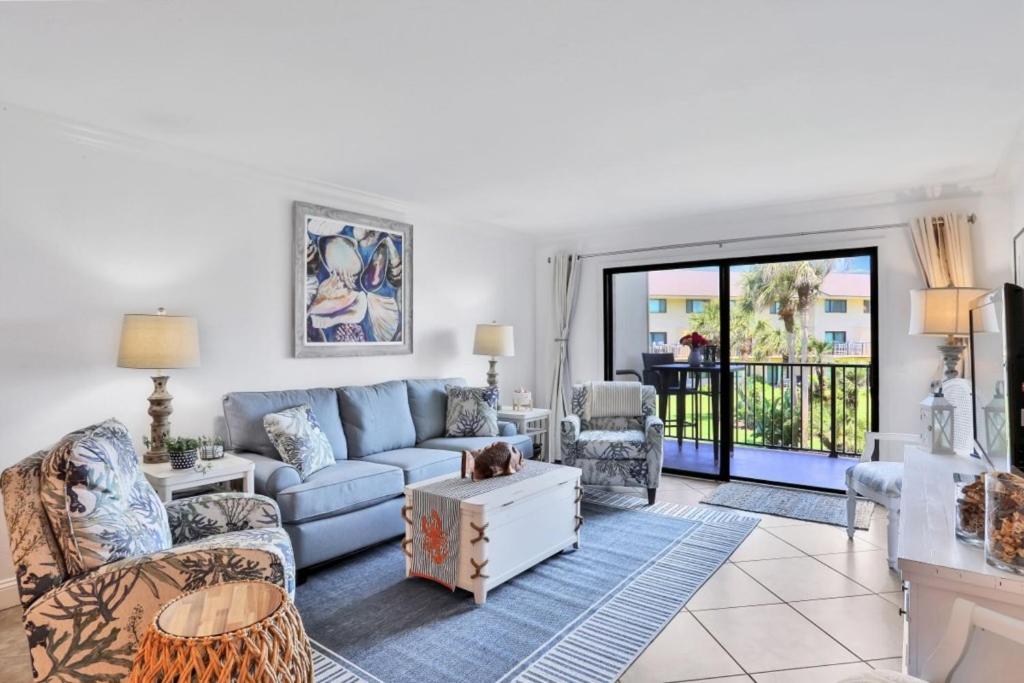 a living room with a blue couch and chairs at Summerhouse 147 in St. Augustine