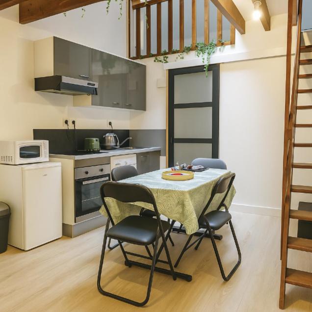 une cuisine avec une table et des chaises dans une pièce dans l'établissement Charmant et paisible duplex à gare Rennes, à Rennes
