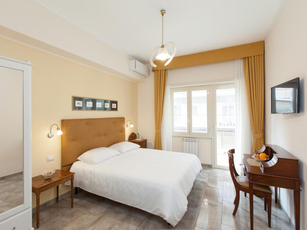 ローマにあるAnice Affittacamereのベッドルーム1室(白いベッド1台、デスク、窓付)