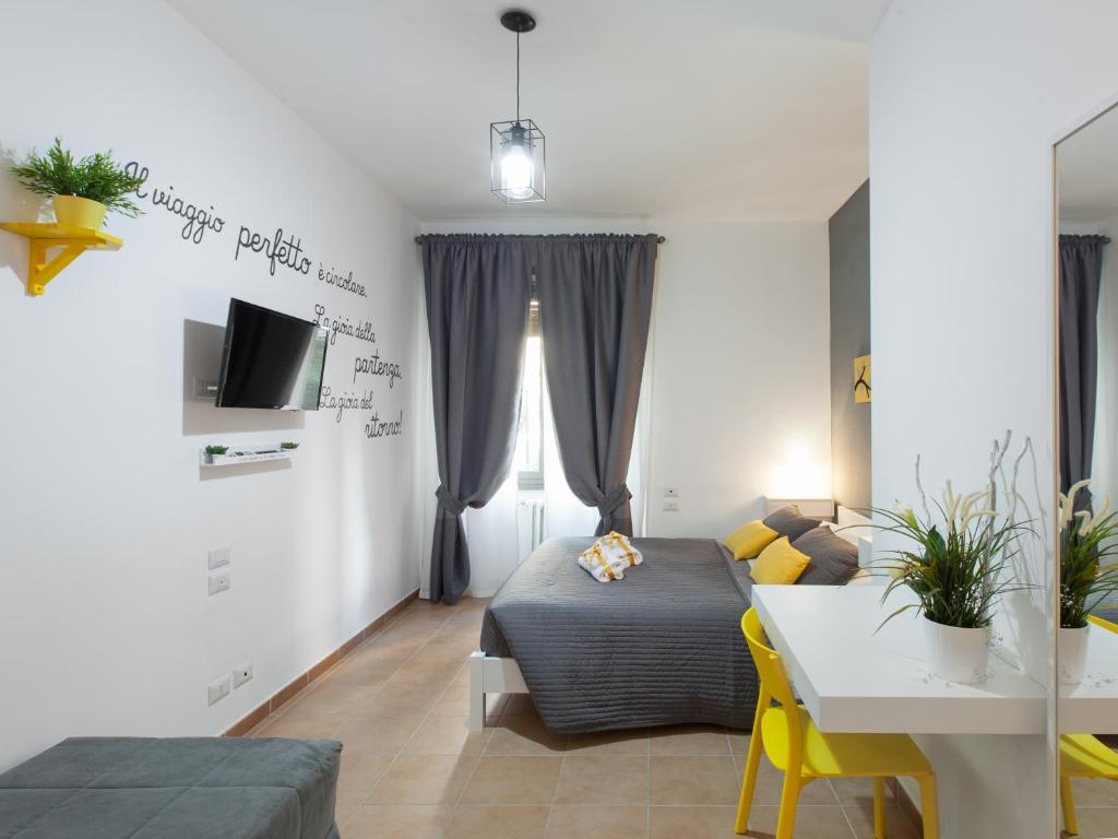een slaapkamer met een bed en een tafel en een televisie bij Dormi a Roma in Rome