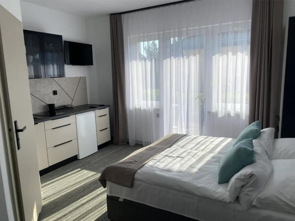 a bedroom with a large bed and a kitchen at Laguna Blue in Grzybowo