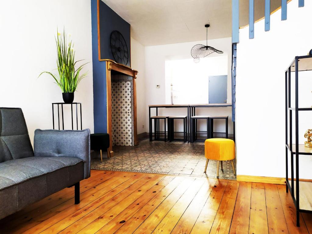 - un salon avec un canapé et un tabouret jaune dans l'établissement La Manutention de Saint-Omer, à Saint-Omer