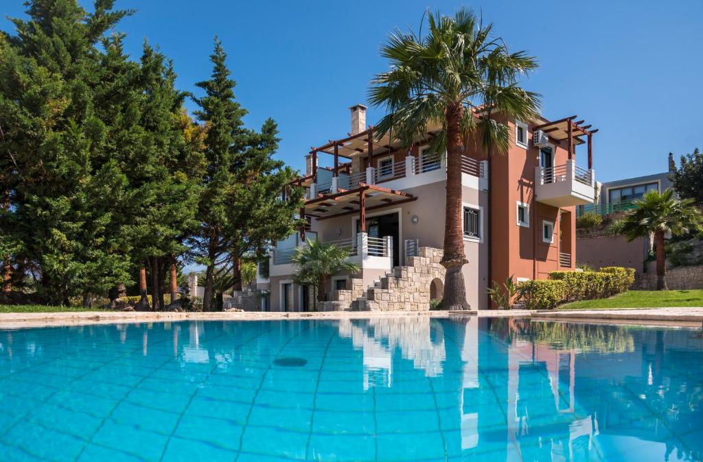 uma grande piscina em frente a uma casa em Athina Luxury Villas em Xamoudhokhórion