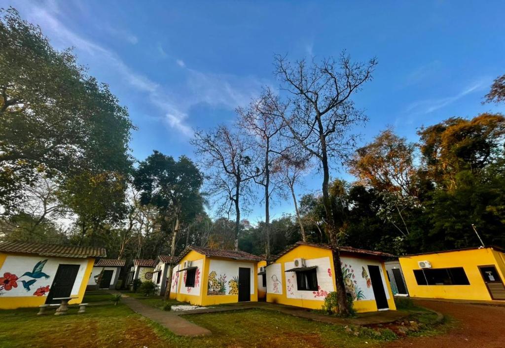 a row of yellow and white cottages at Pousada Cidade Linda in Foz do Iguaçu