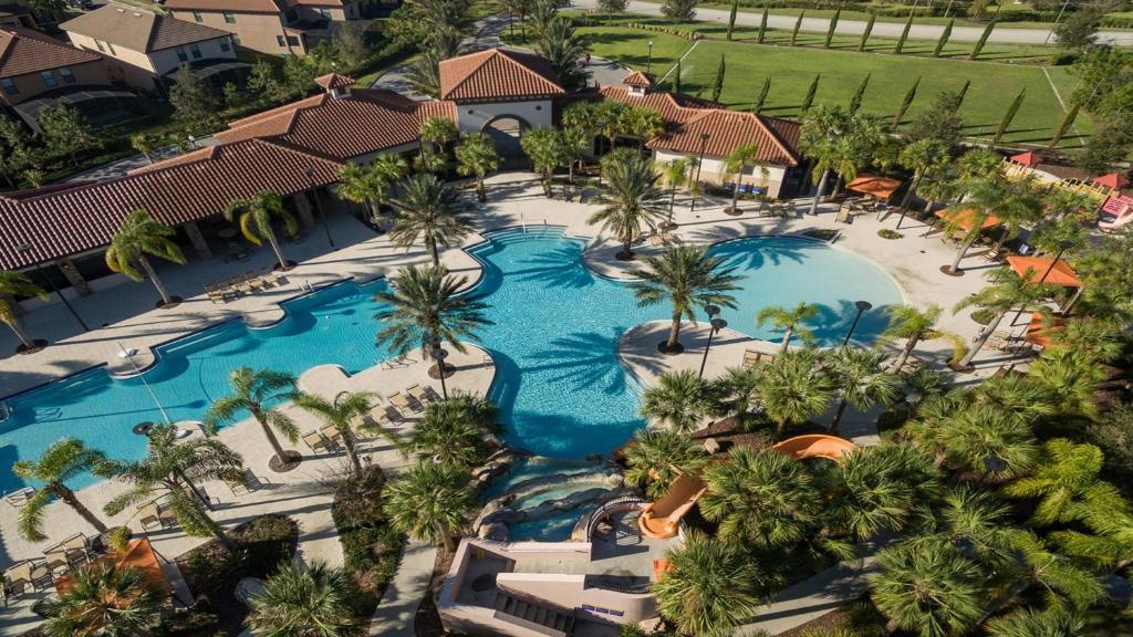 Una vista aérea de la piscina de un resort con palmeras. en Solterra Villa with Screened Pool & Lake View, en Loughman
