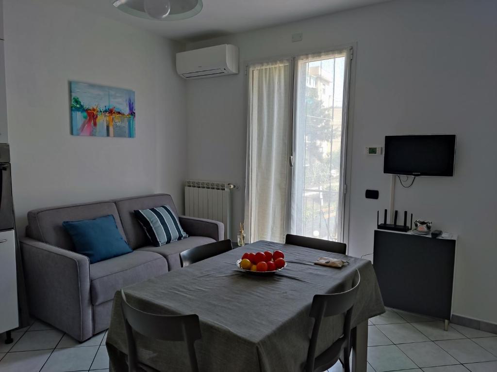 Una sala de estar con una mesa con un bol de fruta encima. en Appartamento Camineve 2, en Loano