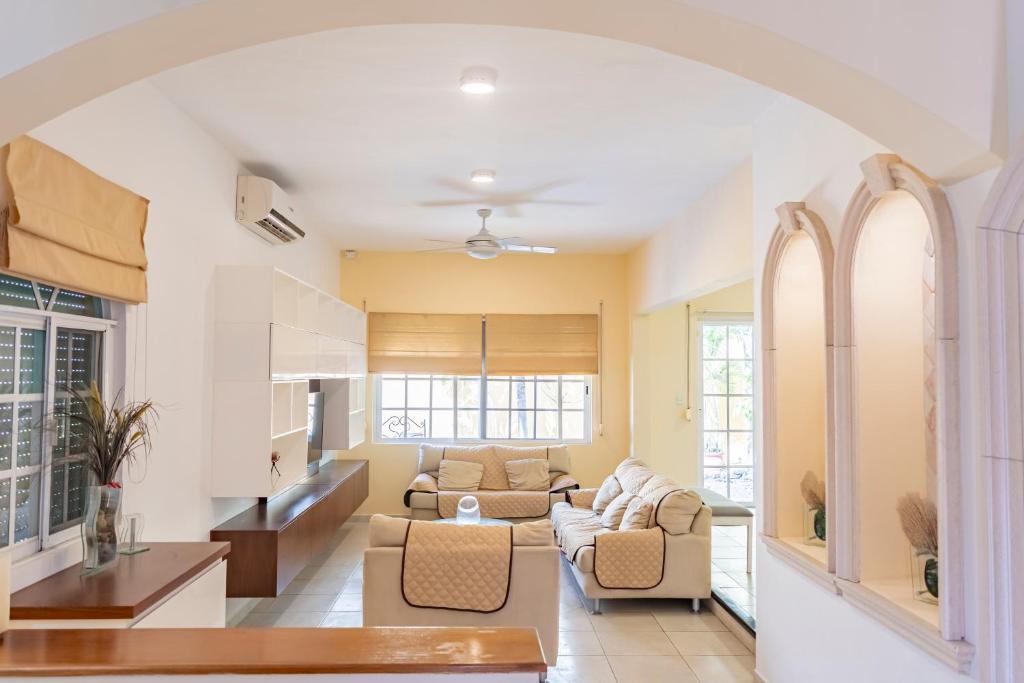 an open living room with a couch and chairs at Punta Piedra By Andiani in Cancún