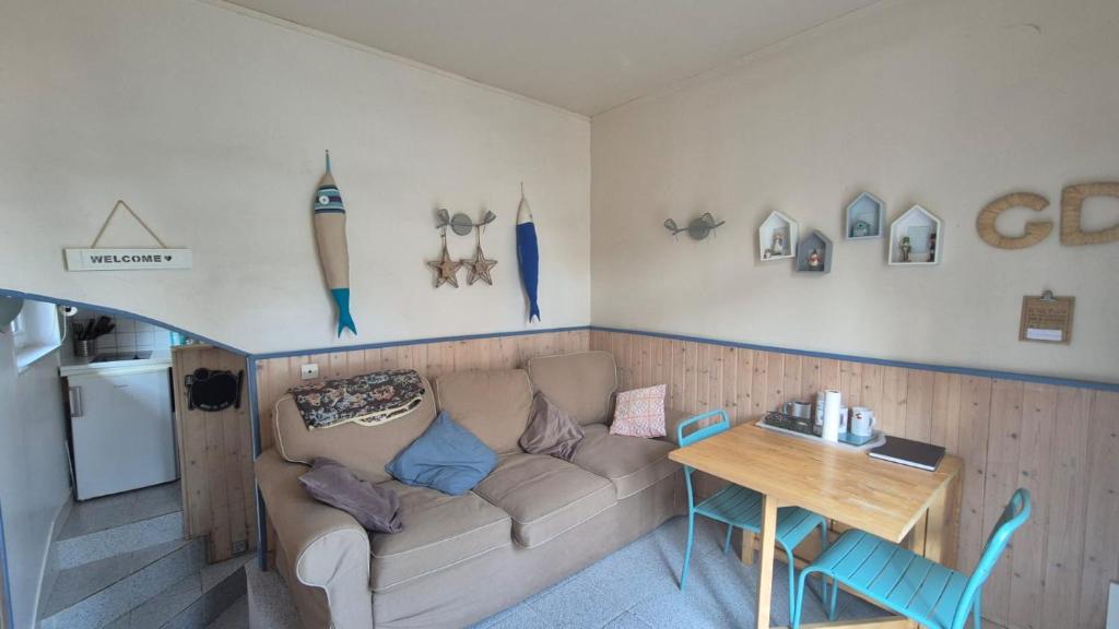 a living room with a couch and a table at Type 2 hypercentre 100 m de la mer in Cabourg