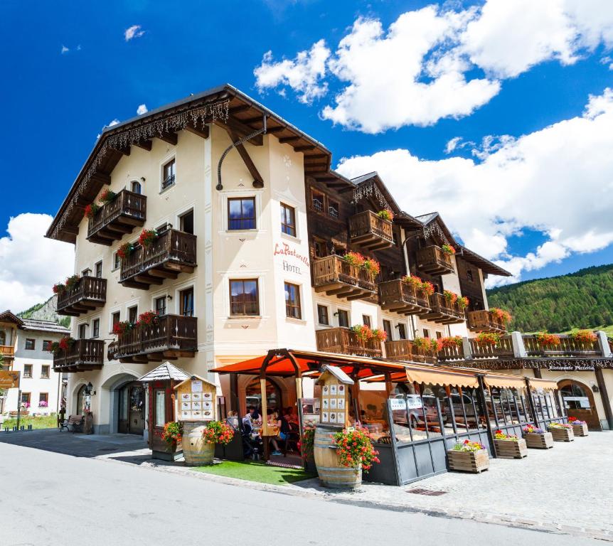 a large building with balconies on the side of it at Hotel La Pastorella in Livigno
