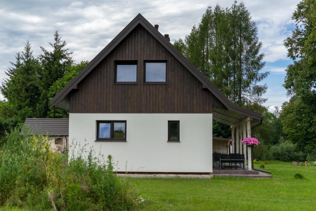a white house with a brown roof at Wigierska Piertówka in Leszczewo