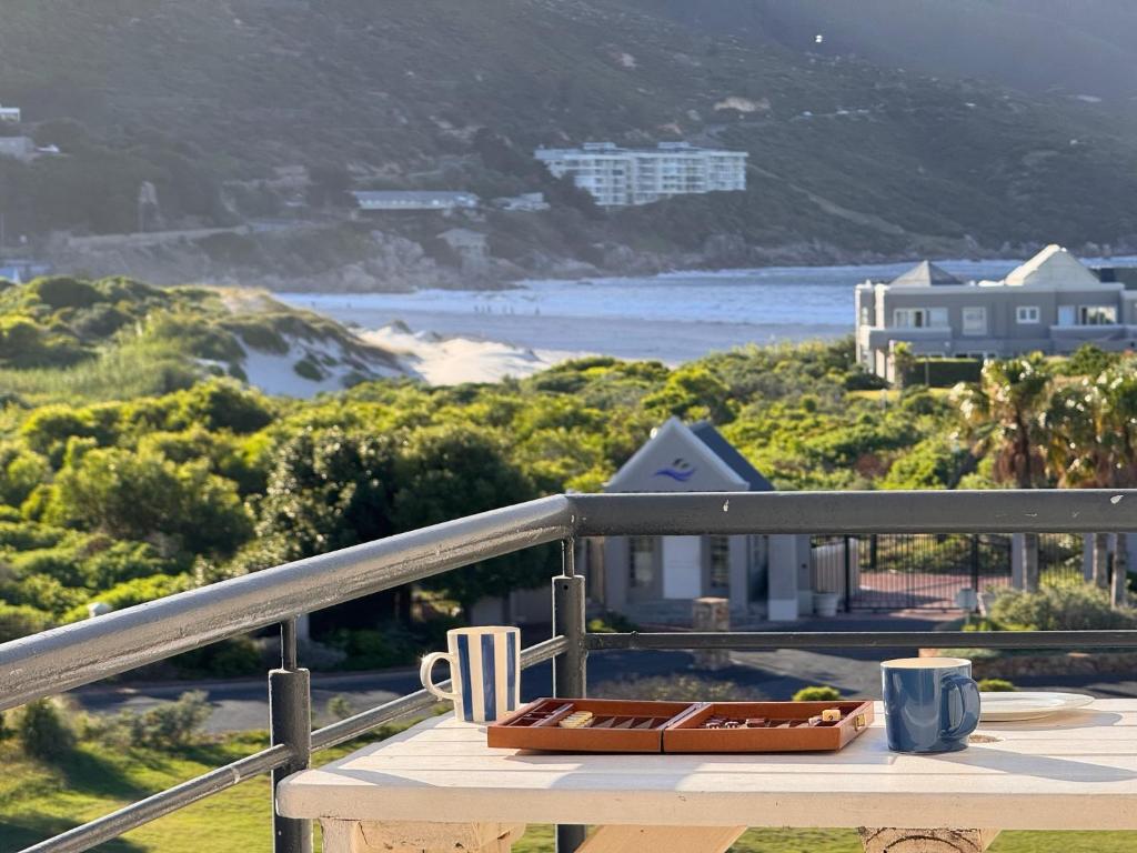 a table on a balcony with a view of the beach at Beachview Apartment in Hout Bay