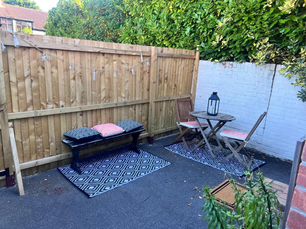 a patio with a table and chairs and a fence at Cosy one bed central Fareham in Fareham