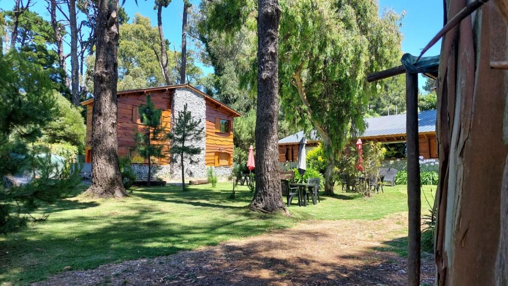 a log cabin with trees in front of it at Cabañas Altos del Bosque in Mar del Plata