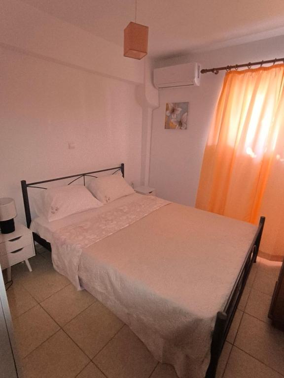 a bedroom with a large bed with white sheets at Johanna's apartment in Preveza