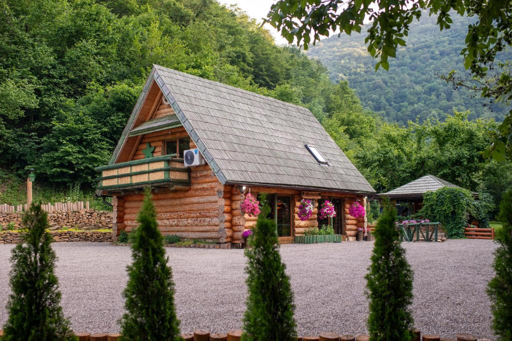 a log cabin with a porch and a balcony at Villa Bosnia in Donji Vakuf
