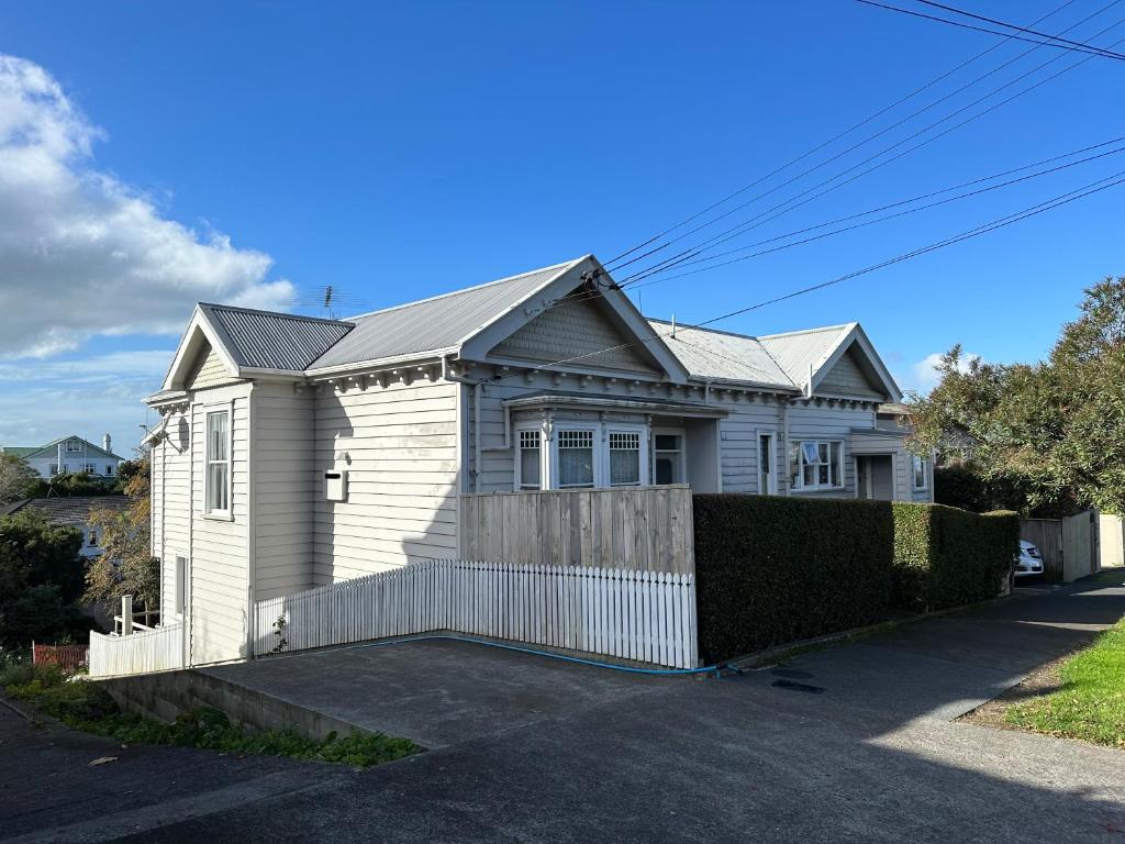 a white house with a fence in front of it at One Bedroom Villa Spacious Room,Amazing Location All Perks in Auckland
