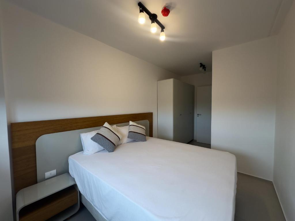 Un dormitorio con una gran cama blanca con dos almohadas. en Departamento en Luque cerca a Asunción 210, en Luque