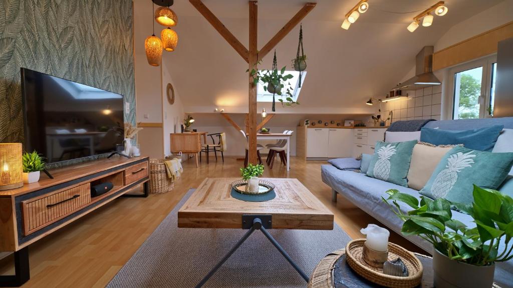 a living room with a blue couch and a tv at Treetop Apartment - Schwarzwald und Schwäbische Alb in Eutingen
