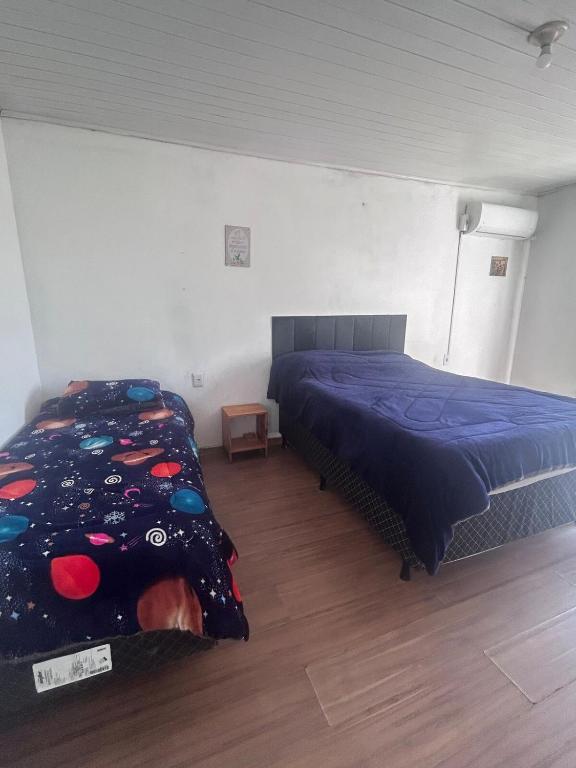 a bedroom with a bed with a blue comforter at Casa simples e confortavel, próx ao centro de pelotas in Pelotas