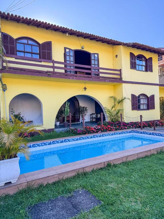 a house with a swimming pool in front of it at Pousada Casa Recanto da Serra in Petrópolis