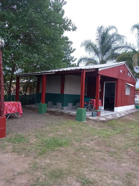 a red shed with a table and chairs in a yard at Cabañas del Valle JONIVA in Termas de Río Hondo