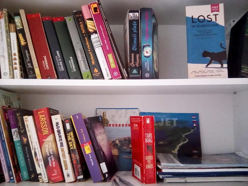 a book shelf filled with lots of books at Hostel Saint Ursula Rooms in Dubrovnik